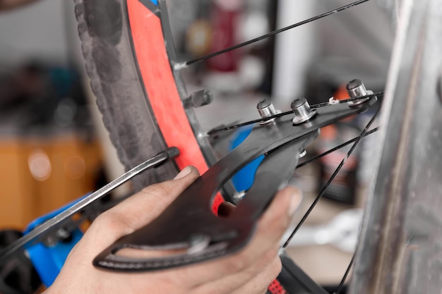 O mecânico da bicicleta usa o calibre de tensão verifica quanto esticou a roda da bicicleta
