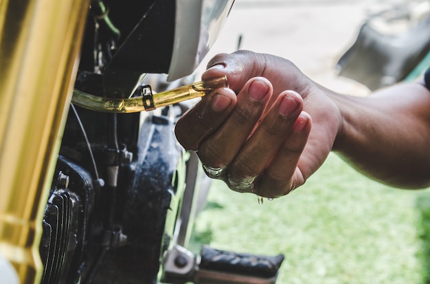 O mecânico está consertando a motocicleta.