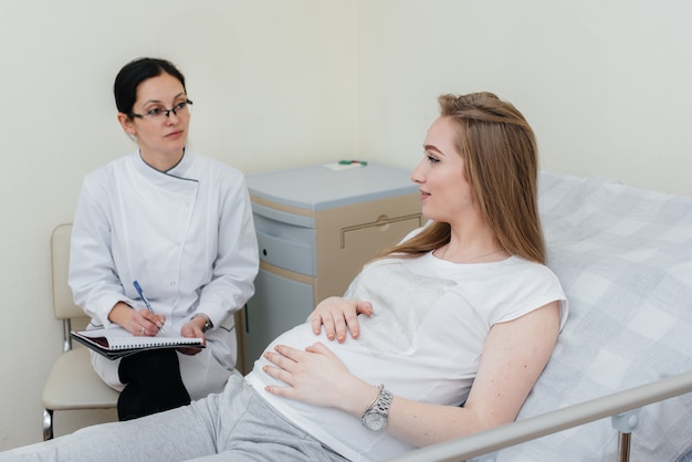 O médico aconselha e atende uma jovem grávida em uma clínica médica. Exame médico