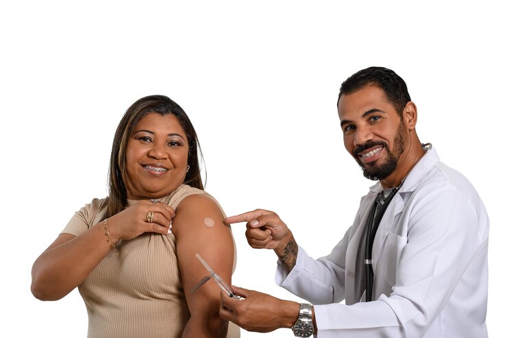 Foto o médico aponta para o adesivo da vacina no braço da mulher sorridente