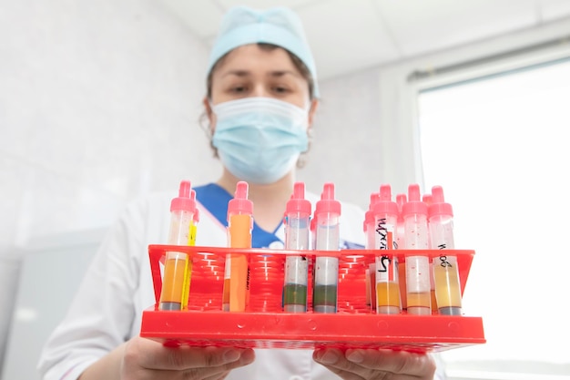 O médico assistente de laboratório tem tubos de ensaio com análises nas mãos