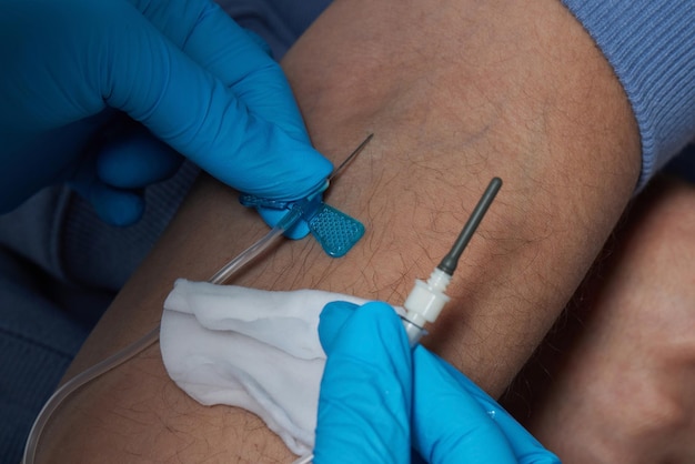 O médico coleta sangue em uma seringa Enfermeira tira sangue das veias do braço