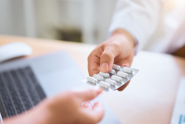 O médico dá remédio ao paciente para alívio da dor.