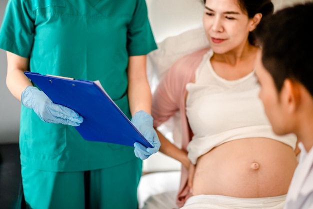 O médico e a enfermeira mantêm o paciente com comprimidos de consulta com a mulher grávida no hospital Conversa de ginecologista feminina consulta gravidez feminina antes de dar à luz Conceito de maternidade