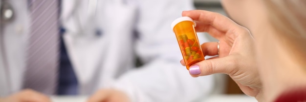 Foto o médico entrega comprimidos médicos ao paciente no consultório da clínica