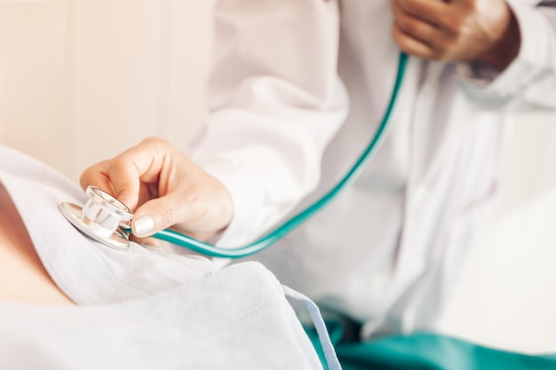 Foto o médico está medindo a freqüência cardíaca do paciente.