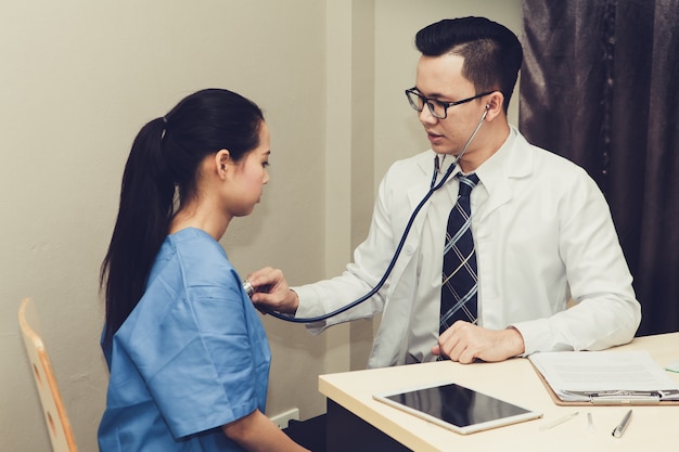 O médico está ouvindo o batimento cardíaco do paciente para diagnosticar a doença.