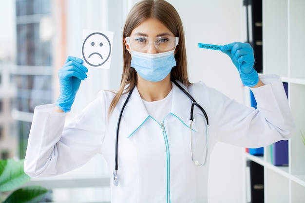 O médico está segurando um cartão com o símbolo Sad Smile no escritório da clínica