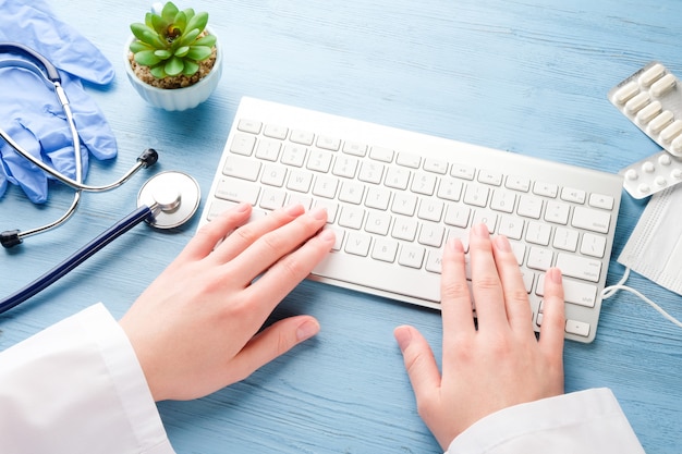 O médico está trabalhando em um computador. Médico à mesa.