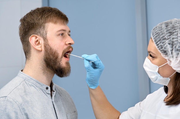 O médico faz um esfregaço para um teste de PCR de um jovem