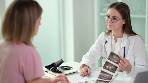 O médico ginecologista se comunica com o paciente e examina os resultados do exame de ultrassom de inte