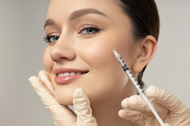 O médico injecta botox a uma rapariga.