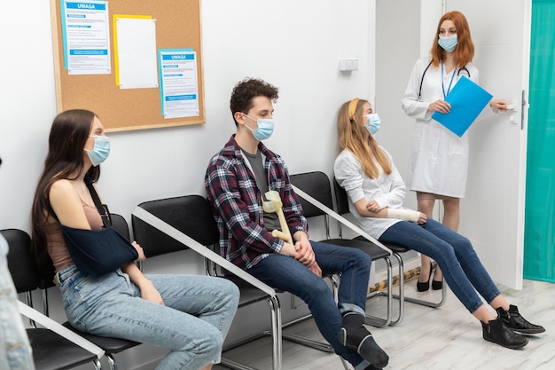 O médico lê a próxima pessoa na fila durante uma pandemia todos devem usar máscaras de proteção