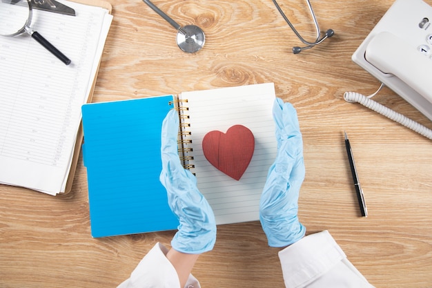 Foto o médico mantém o coração nas mãos