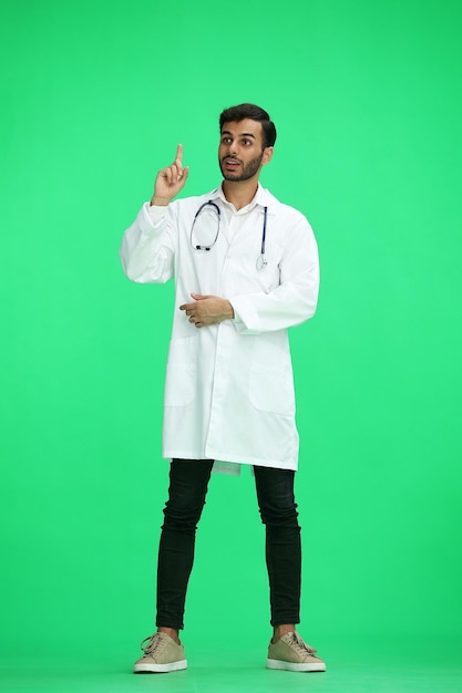 Foto o médico masculino em fundo verde pensa