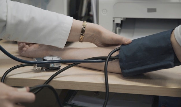 Foto o médico mede a pressão arterial do paciente no hospital