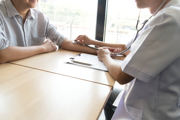 Foto o médico mediu a pressão do paciente com um manômetro.