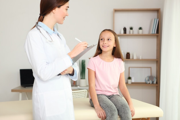 O médico pediatra jovem faz um check-up a uma menina