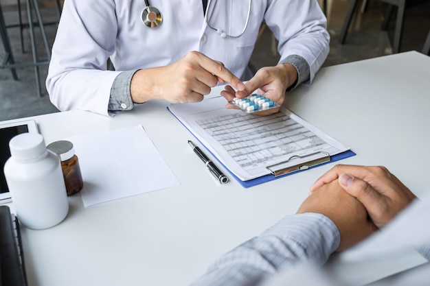 Foto o médico se apresenta com o paciente e verifica os resultados do relatório e da prescrição sobre o problema da doença e recomenda o uso de medicamentos, cuidados de saúde e conceito médico.