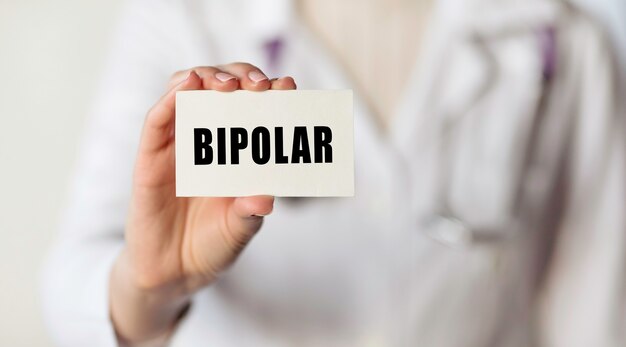 O médico segura um cartão com o texto que significa transtorno bipolar