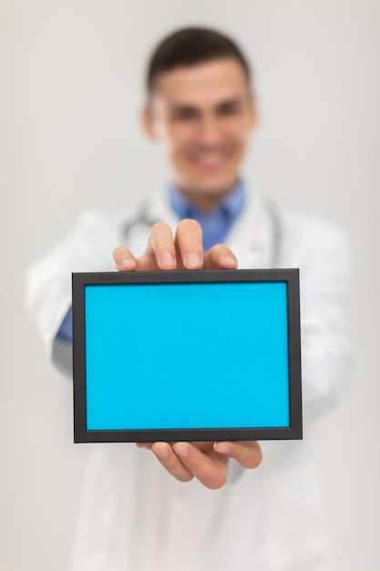 Foto o médico segura um comprimido branco azul em suas mãos pronto para colocar a inscrição lá