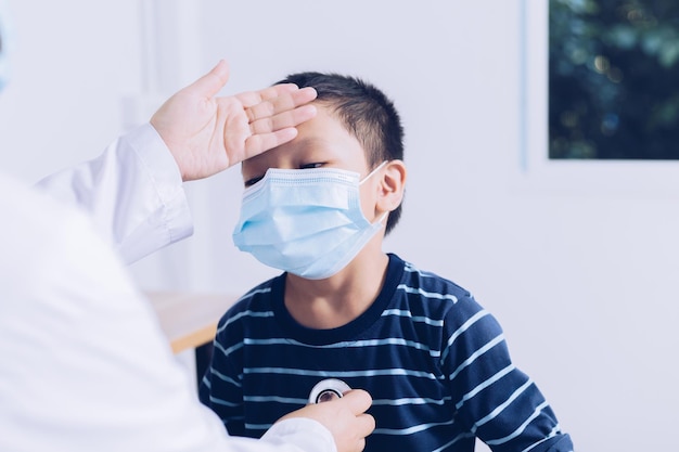 O médico senta-se no trabalho examinando um paciente infantil