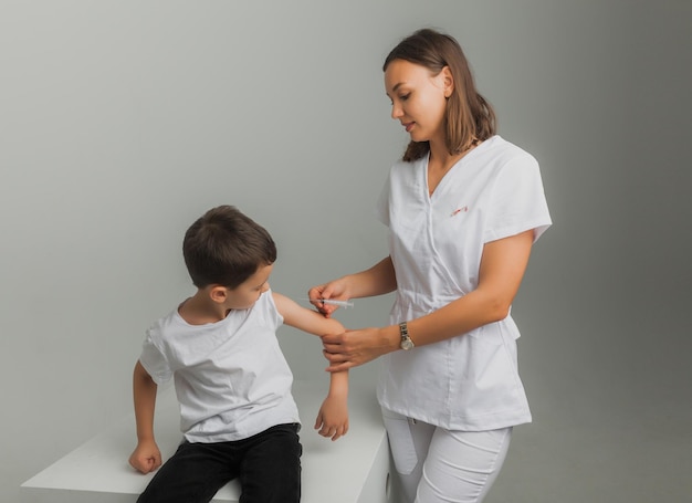 O médico vacina o menino no braço. Surto de coronavírus. Conceito de vacinação. foto de alta qualidade