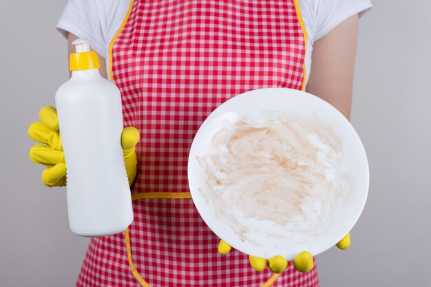 O melhor produto para remover a gordura de louças é usar um bom conceito de detergente. Cortado perto de um trabalhador do restaurante chateado, mostrando em branco da placa de molho de chocolate parede cinza