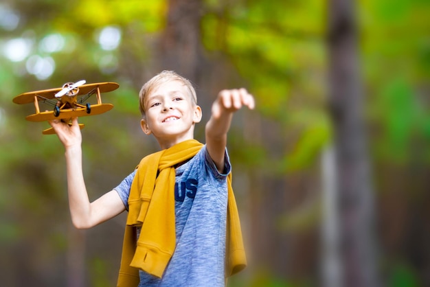 O menino brinca com um avião de brinquedo no parque Dream