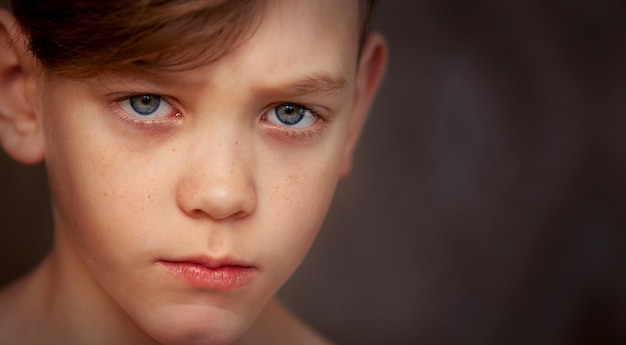 Foto o menino chateado está olhando para a câmera