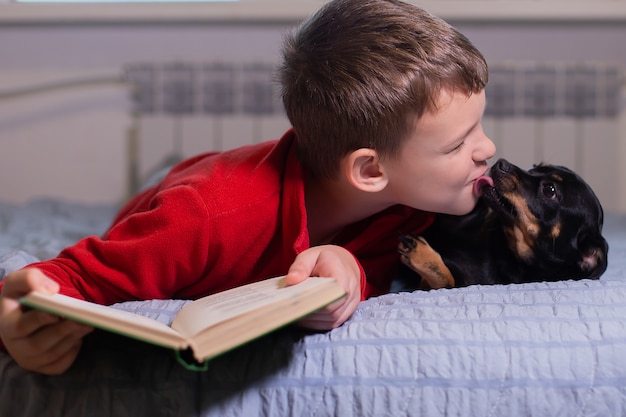 O menino com cachorro em casa, descansando