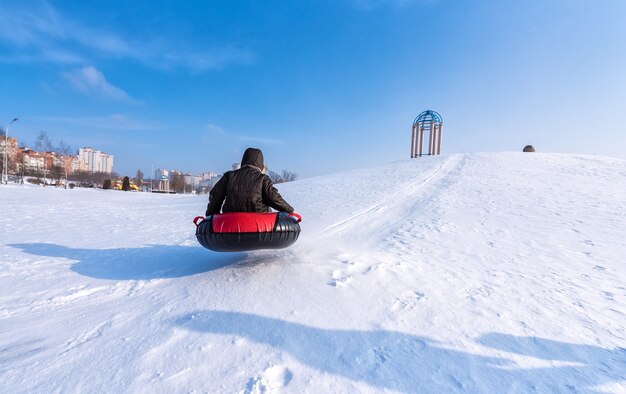 O menino está andando de bóia no inverno