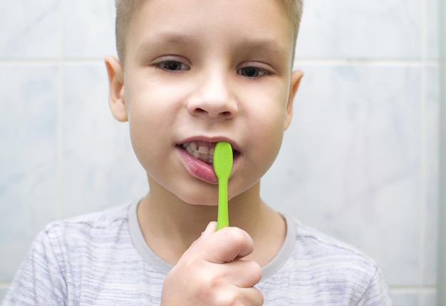 O menino está escovando os dentes Higiene oral