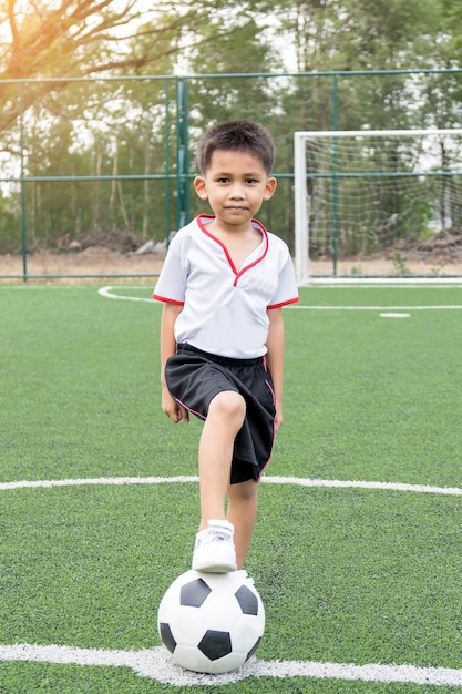 Foto o menino estava jogando futebol no campo de futebol com felicidade.