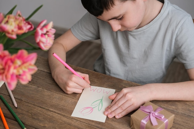 O menino faz um cartão para o dia das mães desenhos infantis