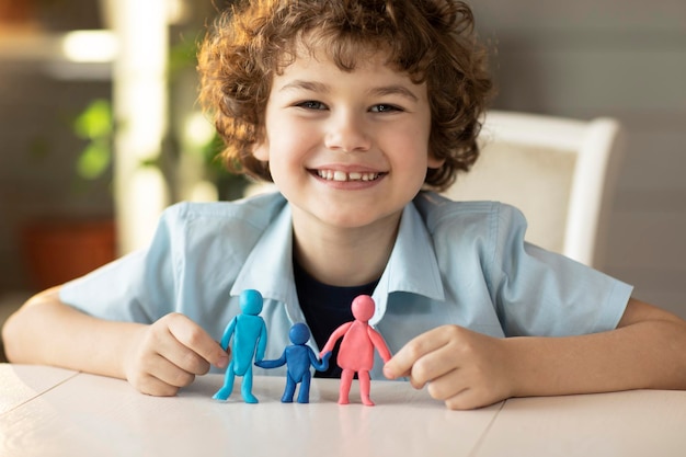 O menino fez figuras de pessoas de plasticina pai mãe e filho sorrisos felizes na câmera