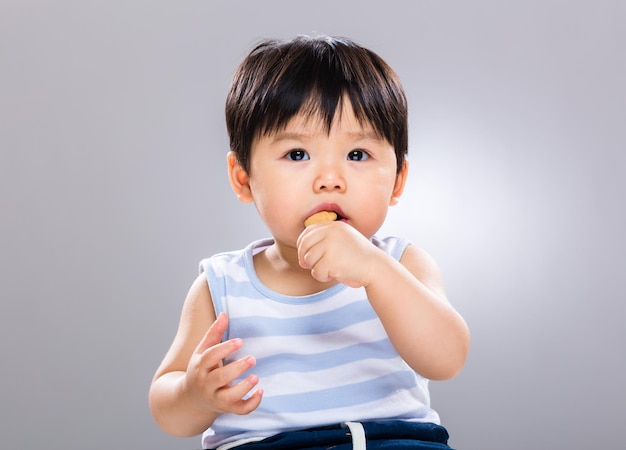 O menino gosta de comer comida com dedos.