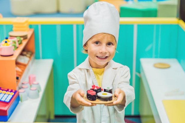 O menino joga o jogo como se fosse cozinheiro ou padeiro na cozinha de uma criança.