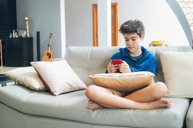 retrato cinematográfico menino jogando no celular enquanto espera por  comida, garoto sentado no café enviando texto para amigos, criança jogando jogo  online no telefone. 9713796 Foto de stock no Vecteezy