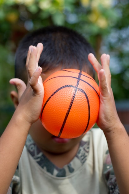 O menino segurando bola na mão.