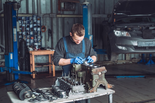 O mestre coleta um motor reconstruído para o carro.