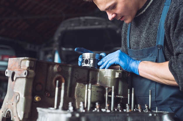 O mestre coleta um motor reconstruído para o carro.