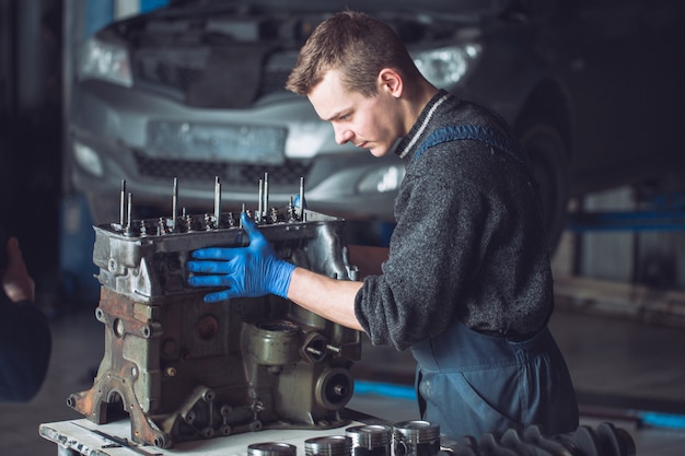 O mestre coleta um motor reconstruído para o carro.