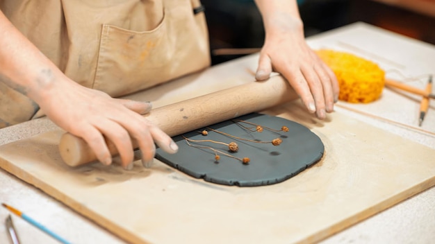 O mestre da escultura em cerâmica trabalhando em um estúdio Comprimindo galhos na argila