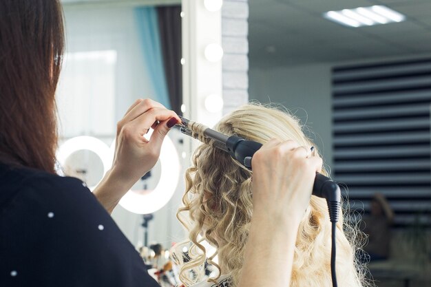 O mestre faz um penteado para uma menina, lindos cachos