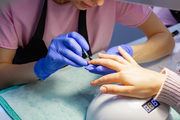 O mestre faz uma manicure no salão