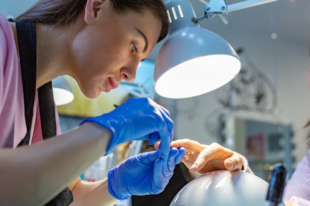 O mestre faz uma manicure no salão