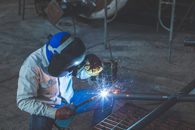 O metal do trabalhador masculino de soldagem faz parte da construção do encanamento do bocal de máquinas