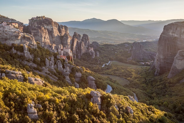 O Meteora ao pôr do sol. Meteora é uma formação de imensos pilares monolíticos e colinas como enormes rochas arredondadas que dominam a área local.