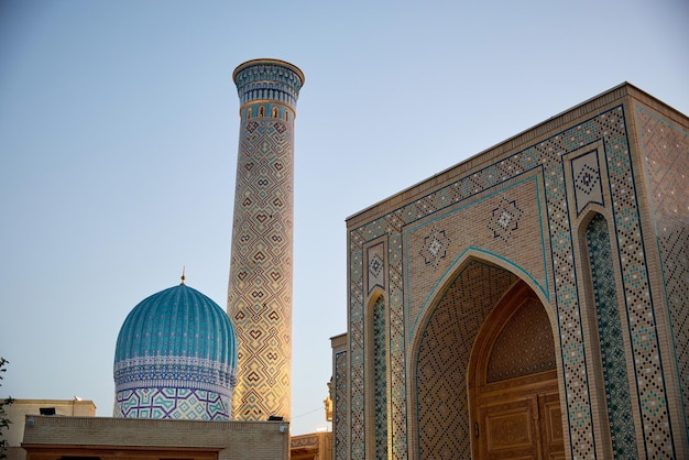 Foto o minarete e a cúpula da madrassa em samarcanda